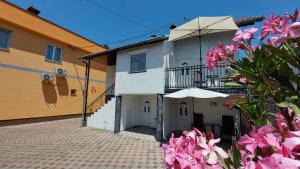 a house with a courtyard with pink flowers at Apartment Kapetanovic in Bosanski Šamac