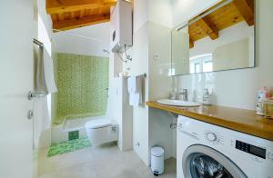 łazienka z umywalką i pralką w obiekcie Apartments Festum w Szybeniku