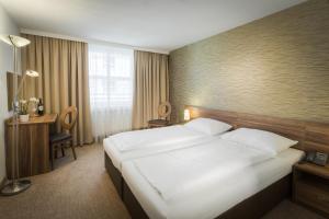 Rúm í herbergi á Hotel Enziana Wien