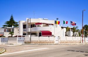 トッレ・デル・オルソにあるDamavi Suite 2の旗の目立つ白い建物