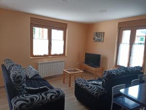a living room with two couches and a tv at Casa El Pastor in Valcovero