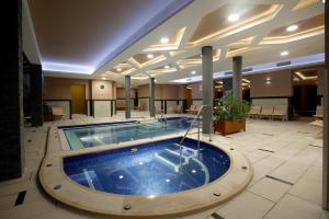 a large swimming pool in a hotel lobby at Hotel Villa Völgy Wellness & Konferencia in Eger