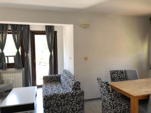 een woonkamer met 2 stoelen en een tafel bij City View Apartment in Fojnica