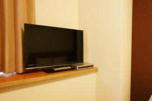 a flat screen tv sitting on top of a wooden stand at Hotel Century Art in Fukuoka