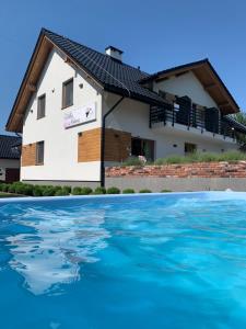 a house with a solar roof and a swimming pool at Villa Natura Zator Przeciszów in Zator