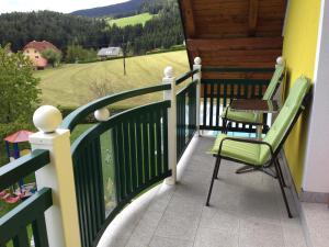 d'un balcon avec deux chaises et une vue sur un champ. dans l'établissement Haus Rose, à Wenigzell