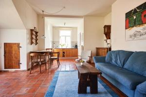 a living room with a blue couch and a table at Hürhus Hude in Hude