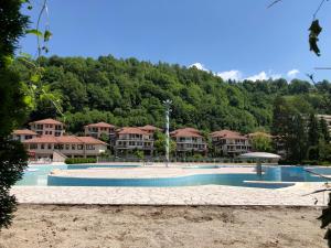 a large swimming pool in front of a resort at Green Oaza Apartment in Fojnica