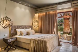 a bedroom with a bed and a large window at Avithos Resort Hotel in Svoronata +37 photos