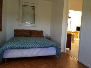 een slaapkamer met een bed in een kamer met een raam bij TY ROZ in Roz-sur-Couesnon