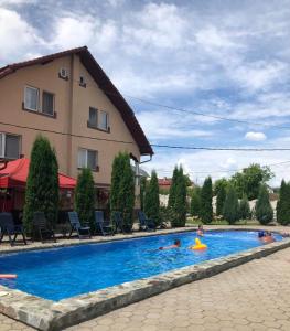 ein Pool in einem Hotel mit Schwimmern in der Unterkunft Giandra Resort in Turda