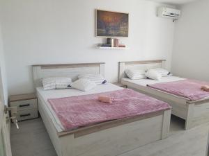 um quarto com 2 camas e lençóis cor-de-rosa em Petra em Bijela