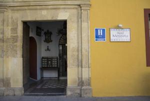 un edificio amarillo con un cartel en el costado en Hotel Casa Museo de la Mezquita en Córdoba