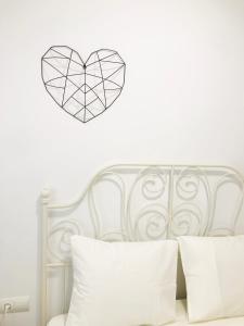 a heart stenciled on a white wall above a bed at PRECIOSO APARTAMENTO con PISCINA in Ruidera