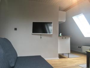 - un salon avec une télévision murale dans l'établissement 2-Zimmer-Apartment in München, à Munich