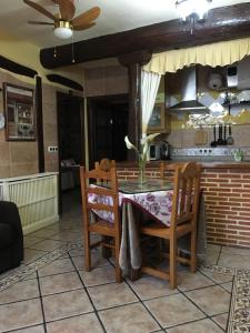 a kitchen with a table and chairs and a ceiling fan at Casa Rural La Antigua Tahona in Candelario