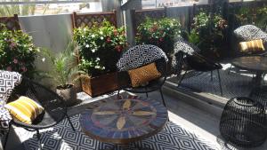 a patio with chairs and tables and potted plants at Villa Zawaia B&B in Lagos