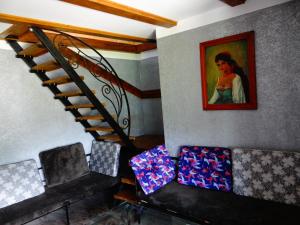 a room with a staircase with a painting of a woman at Pensiunea Lacul Albesti in Albeştii Pămînteni