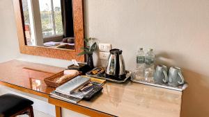 a counter top with a coffee maker and a mirror at K2 Hotel @ Airport in Surat Thani