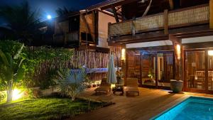 una casa con terraza y piscina por la noche en Akua Concept - Taipu de Fora, en Maraú
