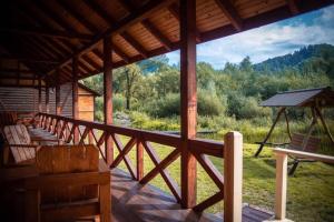a porch of a cabin with a view of the woods at Марканна in Petrashani