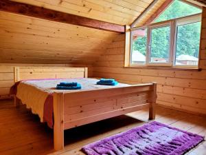 a bedroom with a bed in a log cabin at Марканна in Petrashani