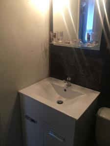 uma casa de banho com um lavatório branco e um espelho. em OUTA Chamonix centre em Chamonix-Mont-Blanc