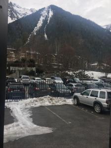 a parking lot with cars parked in front of a mountain at OUTA Chamonix centre in Chamonix-Mont-Blanc