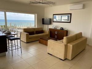 a living room with two couches and a table and a television at LUNA - Airco - Sea view - First line - Own parking in Armação de Pêra