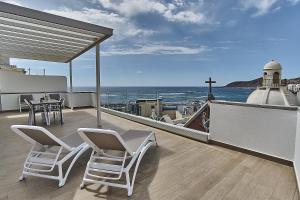 uma varanda com cadeiras e uma mesa e vista para o oceano em Malibú Canteras Ático 23 Vista Mar - Seaview Penthouse em Las Palmas de Gran Canaria