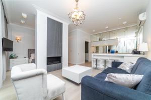 salon z niebieską kanapą i kuchnią w obiekcie Cristal - Neptun Park by OneApartments w Gdańsku +8 zdjęć