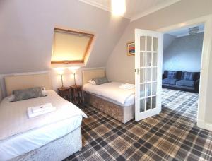 a hotel room with two beds and a couch at The Knowe Guest House in Callander