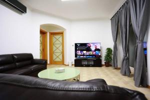 un soggiorno con divano e TV di Villa Sea Breeze a Sowayma