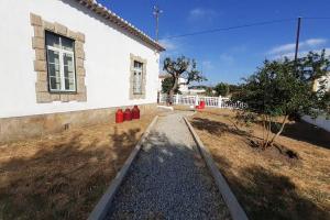 a house with a yard next to a building at Casa dos Corações - Turismo Regenerativo in Beirã