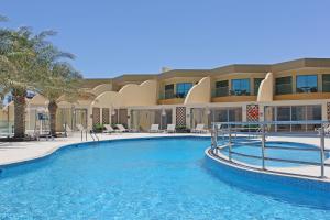 a swimming pool in front of a building at Grand Swiss-Belhotel Waterfront Seef in Manama