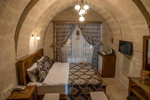 a bedroom with a bed in a room with a window at Underground Cave Suites Hotel in Göreme