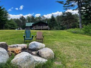 two chairs sitting next to some rocks in a yard at Esther Mountain Chalet in Wilmington
