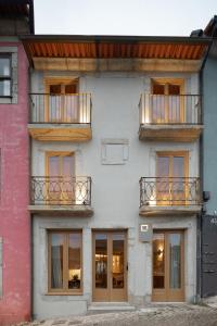 an apartment building with two balconies and windows at Na Travessa Suítes in Porto
