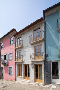 una fila de edificios coloridos con ventanas y balcones en Na Travessa Suítes, en Oporto