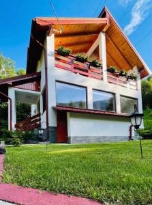 ein Haus mit Fenstern und Pflanzen darauf in der Unterkunft Cabana Nisipoasa in Râu de Mori