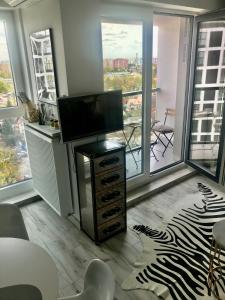 Luxury Wola Apartament في وارسو: غرفة معيشة مع تلفزيون بشاشة مسطحة على خزانة