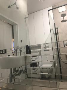 Luxury Wola Apartament في وارسو: حمام مع حوض ومرآة