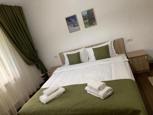 ein Schlafzimmer mit einem Bett mit zwei Handtüchern darauf in der Unterkunft Cabana Nisipoasa in Râu de Mori