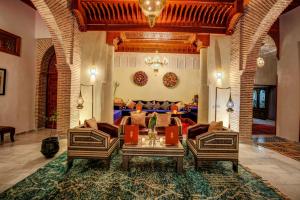 ein Wohnzimmer mit einem Sofa und einem Tisch in der Unterkunft Riad Janate & SPA in Marrakesch