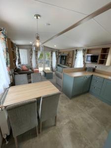 a kitchen and living room with a table and chairs at Pheasant's Hollow - 2 bed hot tub lodge with free golf, NO BUGGY in Swarland