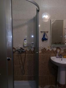 a shower with a glass door next to a sink at kvartira 120 m do pliaj in Batumi +21 photos