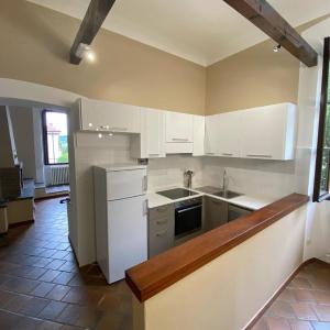 a kitchen with white cabinets and a stove top oven at Crespi d'Adda a "colori" in Capriate San Gervasio