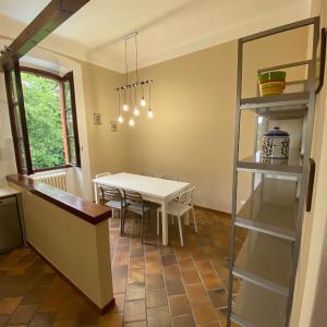 a kitchen and dining room with a table and shelves at Crespi d'Adda a "colori" in Capriate San Gervasio