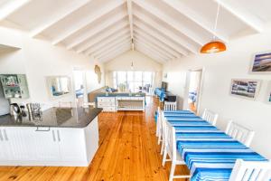 uma cozinha e sala de estar com uma mesa longa com cadeiras em Casa Surf Lodge J'Bay em Jeffreys Bay