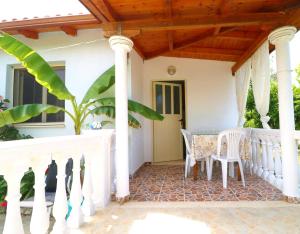 a porch of a house with a table and chairs at Novruzi Complex in Vlorë